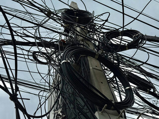 Tightly Bundled Electrical and Communication Cables Wrapping Around Power Pole