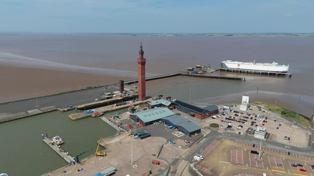 Aerial drone perspective of Clock tower and port harbour area of Grimsby England. Shipping canals and cargo ships, yachts, ferrys and fishing boats, industrial development area.