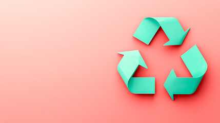 A turquoise recycling symbol made of folded arrows is displayed on a soft pink background, symbolizing sustainability and environmental awareness.