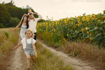 Beautiful family and child with sunflower in spring field