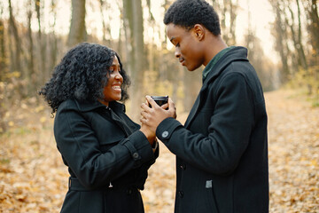 Loving black couple walking in park and enjoying autumn day