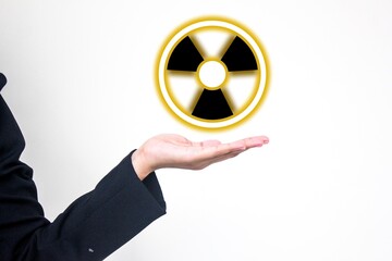 Nuclear presentation concept showing a hand holding a glowing radioactive symbol. Ideal for...