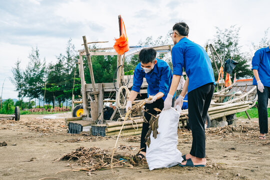 Youth volunteers participate in environmental clean-up efforts at coastal area in Vietnam during afternoon hours