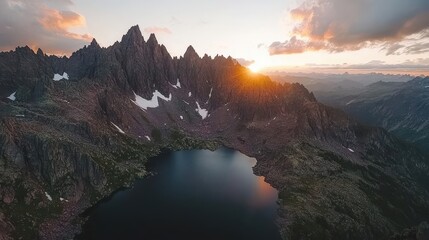 Sunset Over Jagged Mountain Peaks and Reflective Alpine Lake