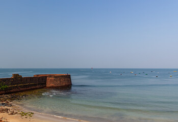 Obraz premium Goan fort wall meets the vast blue sea
