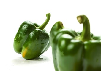 Fresh green bell peppers with water droplets