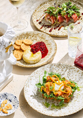 Baked Camembert, tuna roll, and salmon bruschetta in bright, overhead gourmet flatlay composition