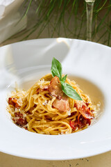 Pasta carbonara with crispy pancetta, bright midday light, closeup centered composition