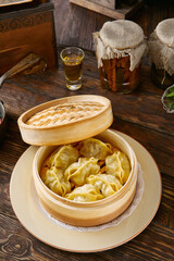 Manty dumplings in a bamboo steamer, rustic natural lighting, overhead composition