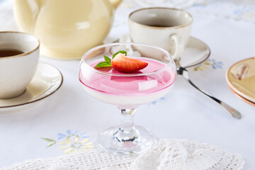 Raspberry souffle dessert in bright overhead composition with vintage teacups and cream tableware