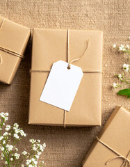 Kraft Paper Gift Box with Blank Label on Burlap Background.photo, commercial, eco, elegant, graphic, image, label, marketing, minimal, present, ribbon, sustainable, warm, branding,