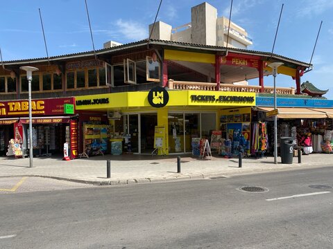 Palmanova, Spain - June 17, 2025: Colorful storefront of LMN travel agency with ticket services, surrounded by local shops and vibrant street life, capturing the essence of a bustling tourist area