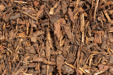 Close-up of bark mulch chippings background backdrop. Used by gardeners for weed control and protecting plant roots from frost.