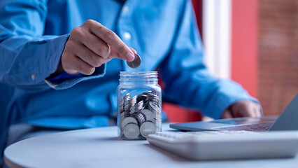 Saving and financial growth concept, professional adding coins into a jar, symbolizing personal finance management, budgeting, and investment planning.