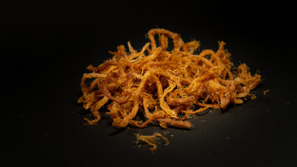 Crispy dried shredded pork isolated on black background. Closeup