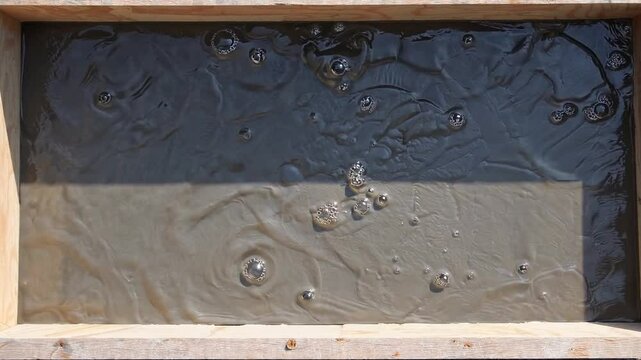 Flowing Gray and Black Liquid Mixture in Wooden Frame for Abstract Art or Industrial Applications