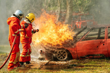 firefighter training fireman team use extinguish spraying fire car. Fire fighter learning stop fire burn under emergency case at fire station. rescue service of Emergency Care System of Insurance team