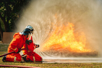 firefighter training fireman team use extinguish spraying fire oil station training. Fire fighter...