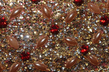 A close-up view of a textured surface adorned with an array of small, sparkling rhinestones in...