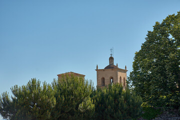 The bell tower of the Church of Santa Maria la Mayor in Trujillo, peeking out from the dense...