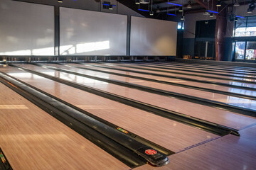 Modern bowling alley interior with multiple empty lanes and soft natural light, November 7, 2020