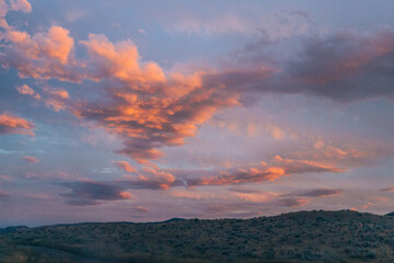 Vibrant sunset clouds over rolling hills in Lac Du Bois Grasslands