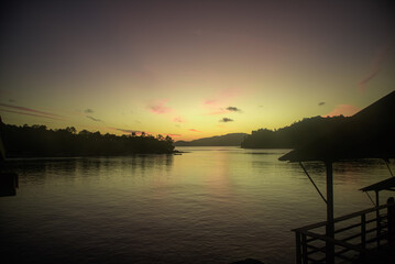 Tropical Sunset View from a Wooden Cottage by the Calm Bay