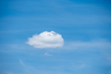 Single cotton-like cumulus cloud floats in a brilliant blue summer sky, June 20, 2020