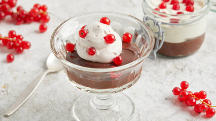 Chocolate cream made from beans with whipped cream and currants in a glass