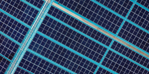 Rows of solar panels on a blue-roofed building, converting sunlight into clean energy.