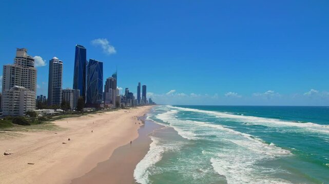 Breathtaking aerial flight along Brisbane's coastline showcasing ocean waves, golden sandy beaches, and towering city skyscrapers. Captures coastal-urban harmony.