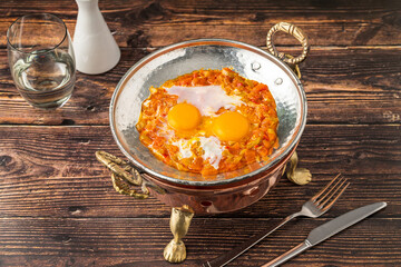 Traditional Turkish menemen with eggs, tomatoes, and peppers in copper pan