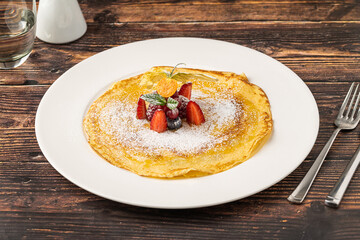 Thin crepe topped with powdered sugar and fresh mixed berries