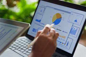 Business analyst reviewing digital charts and data on interactive performance dashboard.