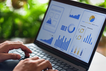 Hand analyzing interactive business dashboard with data charts and performance metrics on digital screen.