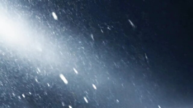 A blizzard rages under a pale, ethereal light, countless snowflakes blurring in a furious, diagonal descent across the dark night sky