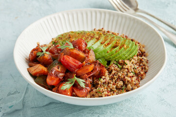 Quinoa bowl with avocado, nuts and tomatoes