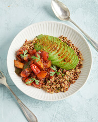 Quinoa bowl with avocado, nuts and tomatoes