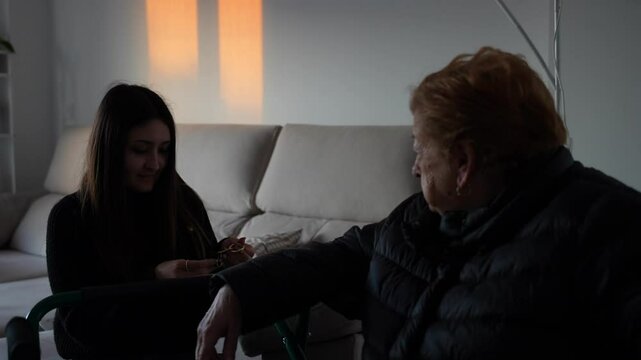 Grandmother watching granddaughter try new keyring at home in warm sunset light