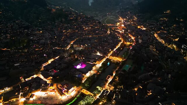 Aerial night view of Xijiang Miao Village, also known as Xijiang Qianhu Miao Village, is the largest Miao ethnic village in the world, located in Guizhou, China.