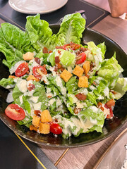 Caesar Salad has many vegetables inside. Sprinkle with cheese and dressing.