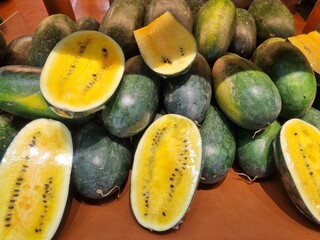 Fresh yellow watermelon on the market stall at supermarket. Slice of tasty yellow watermelon with juicy texture and seeds. Slices of yellow watermelon texture background ideal for fresh produce and he