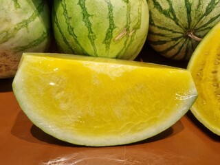 Fresh yellow watermelon on the market stall at supermarket. Slice of tasty yellow watermelon with...