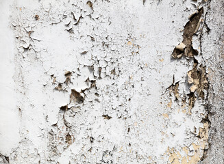A wall with peeling paint and a rough texture