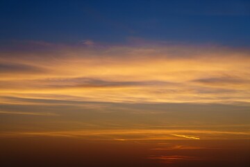 Experience the stunning beauty of a fiery sunset, where vibrant blue, orange, and red hues blend harmoniously above the horizon, creating a peaceful and captivating visual.