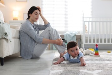 Woman suffering from postpartum depression with her little baby at home. Space for text