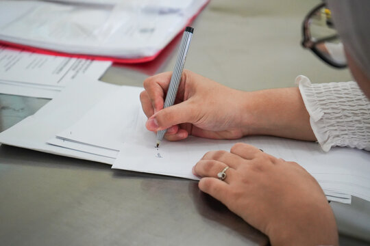 Photo of a hand writing on paper, close up photo of a business woman writing on paper with a pen - Powered by Adobe