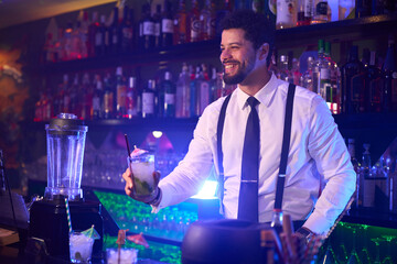 Bartender offering cocktail in nightclub bar setting