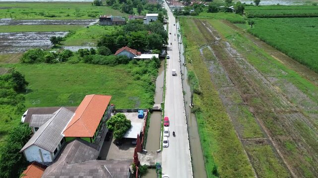 Aerial view from above of houses and fields along the road on the outskirts of the village in the Mojokerto area. East&nbsp;Java,&nbsp;Indonesia