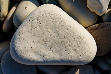 Discover the tranquility of a smooth, light-colored beach stone in this close-up image. Its natural...